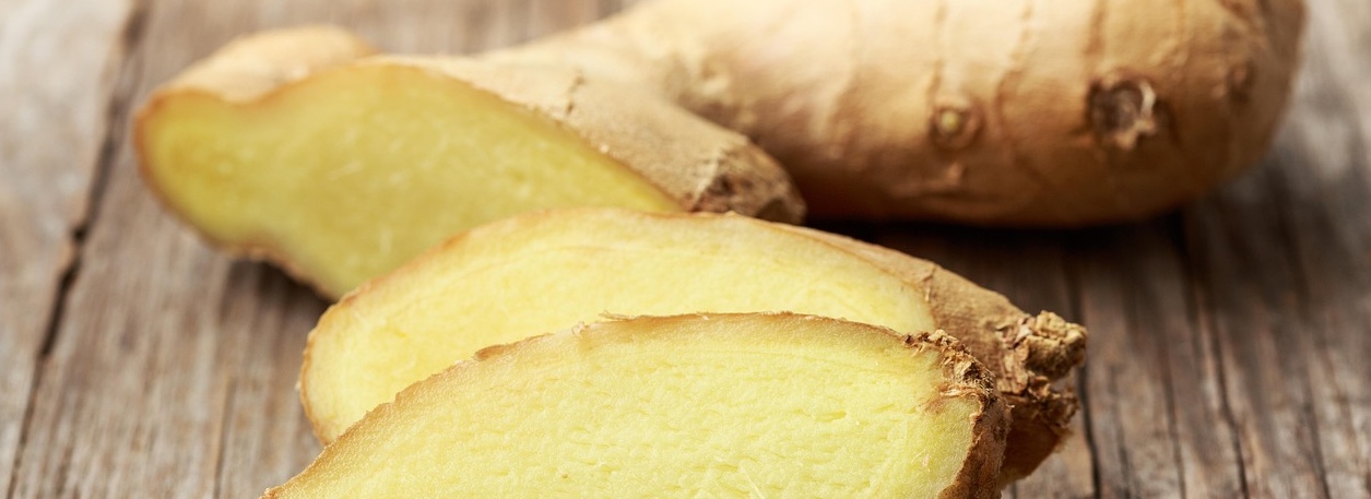slices of raw ginger on a wooden chopping board
